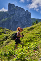 Naklejka premium Woman hiker with poles and backpack