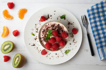 Delicious raspberry mousse with red berries from an overhead perspective.