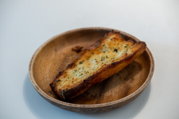 Garlic Bread served on wooden plate on the table