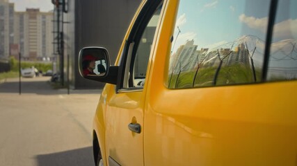 Tracking cropped shot of yellow van being driven by male delivery service worker