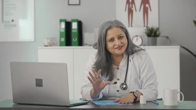 Happy Indian female senior doctor giving medicine to the patient