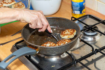 Meat burgers or cutlet-shaped patty being shallow fried in oil on a frying pan, close up. version of cutlets - kotlety.