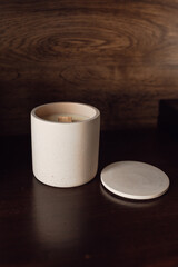 Aromatic premium soy candle in pink concrete jar on wood background. Banner for candle shop. Mock up