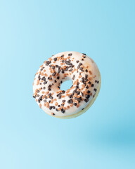 Fresh donut on blue background. Minimal food concept.