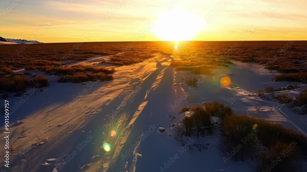 Canvas Prints The last rays of sunlight illuminating the frozen landscape in a warm golden light during a sunset over the tundra.