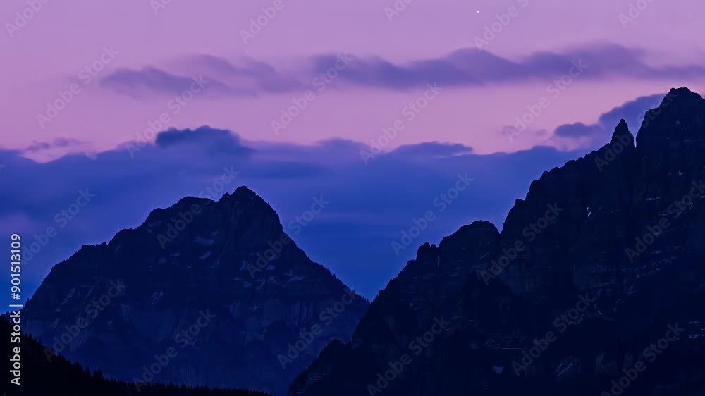 Poster As the light fades the mountains take on a mysterious beauty their jagged edges blending with the fading sky in a magical display of colors.