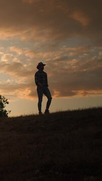 A man walking on a hilly sunset, evoking solitude, contemplation, freedom in scenic outdoor space