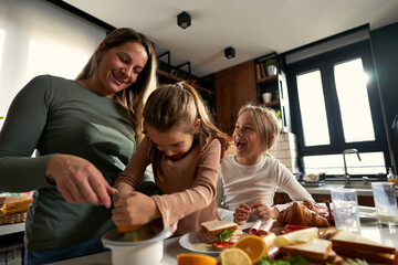  Laughter echoes in the kitchen as mother and daughters squeeze oranges, creating a refreshing touch to their delightful breakfast.