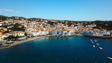 Fototapeta premium aerial view over the Badia de Cadaqués, to the old white houses of Cadaqués, Port Alguer and the Mediterranean Sea, Girona, Catalonia, Spain