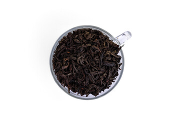 Сup with black tea leaves isolated on white background.