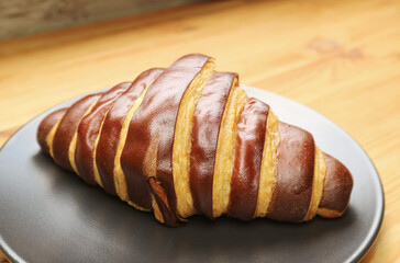 Closeup of a Bicolored Chocolate Croissant Served on Wooden Table