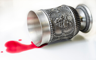 A goblet with a scene representing two lovers, overturned from which a heart-shaped stain of red wine flows. Betrayal, poisoning concept composition