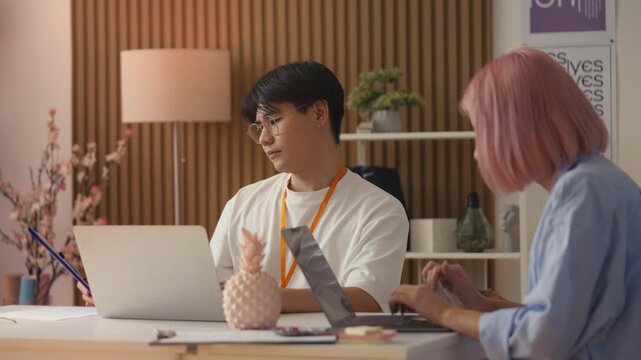 Multiracial web designers working on laptops in office, creating a website