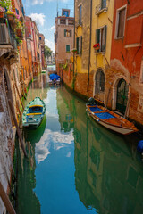 Venice, Italy - June 05, 2024: Venetian Waterway and Architecture. Moored boats on the foreground.