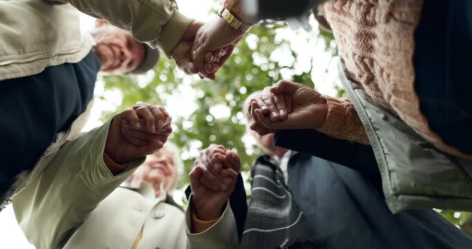 Nature, holding hands and senior people praying for religion, worship or spiritual belief. Hope, group and elderly friends with prayer together for retirement blessing or gratitude in park from below