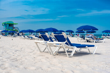 Blue parasols and chaise lounges facing the beach. At Miami Beach, Florida.