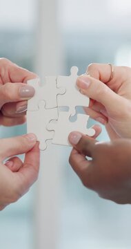 Business people, hands and teamwork with puzzle for problem solving, synergy and integration in office. Employee engagement, group and jigsaw piece for partnership, solution and company interaction