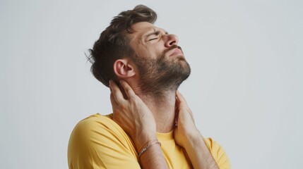 Fototapeta premium Neck ache, tension, and man in studio with arthritis, fatigue, and burnout on white background. Indian model sick, injury, and muscle massage for first aid, emergency, or tiredness frustrated.
