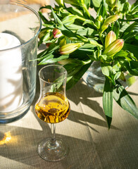 Amaretto almond liquor, sweet alcohol drink, brown Italian liquor made from apricot kernels, on summer table