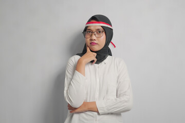 A woman in a white shirt and black headscarf with red and white headband