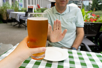 Reject a glass of beer, man refusing alcohol, stop drinking, sobriety concept, saying no to beer...