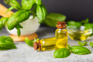 Basil essential oil on a textured wooden background. Basil essential oil and fresh leaves. Aromatherapy. Aroma oil. Medical herbs. Alternative medicine. Place for text. Copy space.
