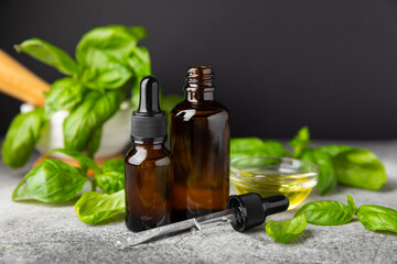 Basil essential oil on a textured wooden background. Basil essential oil and fresh leaves. Aromatherapy. Aroma oil. Medical herbs. Alternative medicine. Place for text. Copy space.