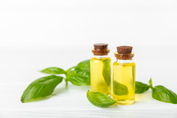 Basil essential oil on a textured wooden background. Basil essential oil and fresh leaves. Aromatherapy. Aroma oil. Medical herbs. Alternative medicine. Place for text. Copy space.