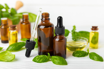 Basil essential oil on a textured wooden background. Basil essential oil and fresh leaves. Aromatherapy. Aroma oil. Medical herbs. Alternative medicine. Place for text. Copy space.