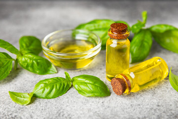 Basil essential oil on a textured wooden background. Basil essential oil and fresh leaves. Aromatherapy. Aroma oil. Medical herbs. Alternative medicine. Place for text. Copy space.