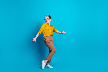 Full length photo of adorable good mood lady dressed shirt eyewear dancing empty space isolated blue color background