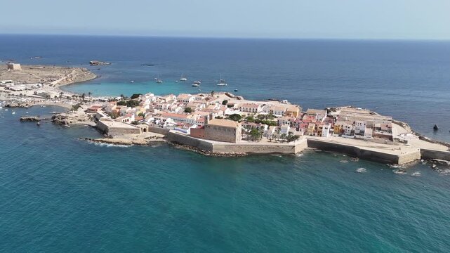 Aerial views of Spanish island Tabarca from different angles. Sunny day, azure waters, yachts docked in the bay. Calm sea, bustling city and beach with tourists. Costa Brava hotspot.