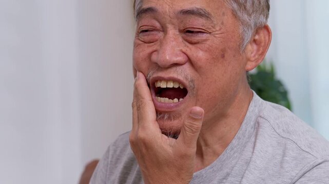 Asia old senior men suffering from severe toothache, holding him cheek and suffering strong dental pain on white background, tooth decay, tooth sensitivity, oral health care concept.