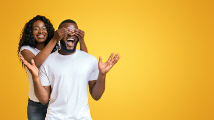 Fototapeta premium Happy Black Woman Closing Her Man Eyes With Her Palms, guy is excited