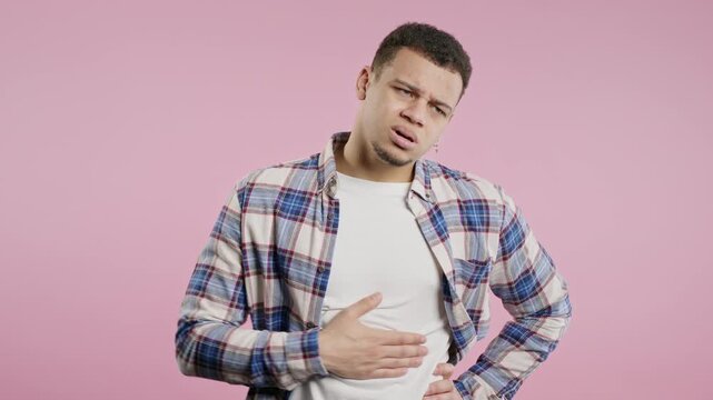 Man squeezing belly with hands because of abdominal pain. Adult guy suffering from stomach ache. Healthcare, problems digestive system, food poisoning or bowel flatulence concept
