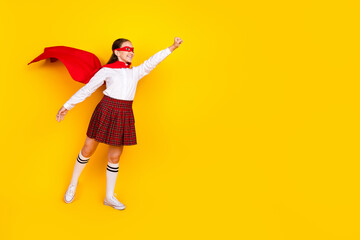 Full length photo of charming teenager pupil girl flying superhero wear trendy uniform isolated on yellow color background