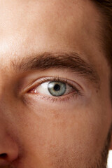 Close-up vertical image of man's eyes, emphasizing clear, bright blue eyes and well-groomed...