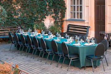 catering served table dishes plates and glass for drinks place ready for dinner without people here now back street alley space