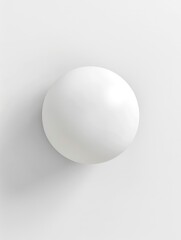 A white ball is sitting on a white wall