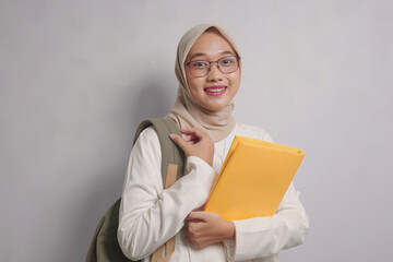 Smiling Woman in Hijab Holding a Folder and Backpack