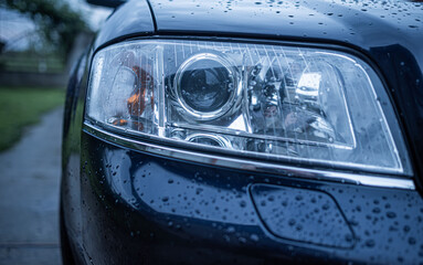 Close-up of wet car headlight.