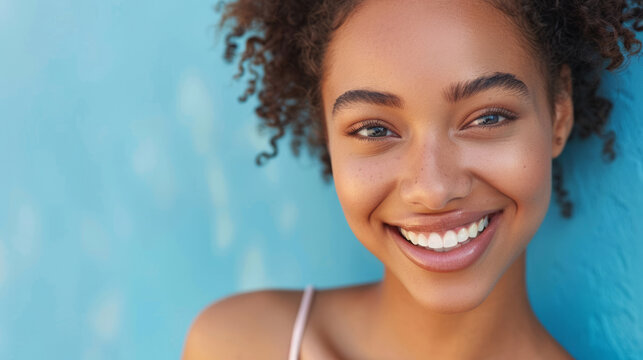 Smiling patient with clear aligners poses against a bright blue background
