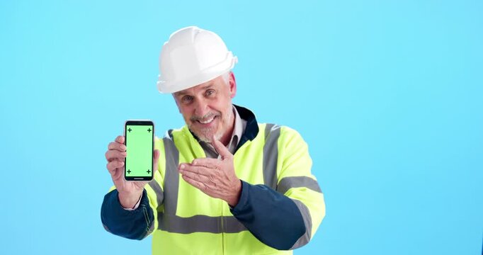 Face, green screen and construction man with smartphone, engineering or network on blue studio background. Maintenance, ux presentation or person with cellphone, pointing or tracking markers with app