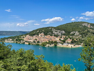 Stunning view from above of the beautiful alpine lake Lac de Sainte-Croix and green mountains in Provence, France