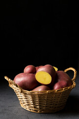 Potatoes in a wicker basket on a dark background