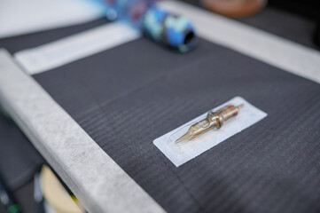 Single-use sealed needle for tattooing on a table for preparing the equipment used in a tattoo studio.