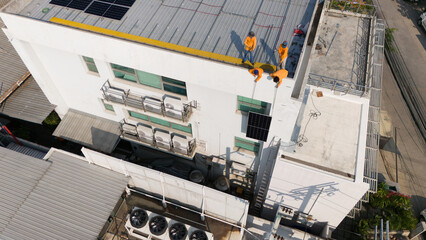 Aerial top view of a technician drone installing solar panels on the roof..