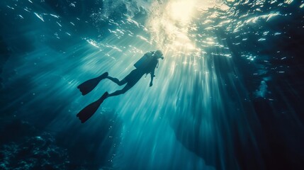 Fototapeta premium Underwater diver swims towards sunlight. Explore the ocean depths with a scuba diver. Adventure awaits beneath the surface of the sea.