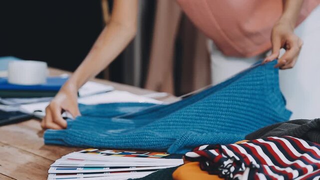 Designer concept.The dressmaker is designing an evening dress in the room.Asian clothing designers are measuring sample sizes to prepare evening gowns for important customer orders