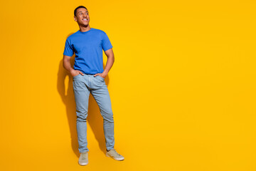 Fototapeta premium Full size photo of pretty young male look empty space wear trendy blue outfit isolated on yellow color background
